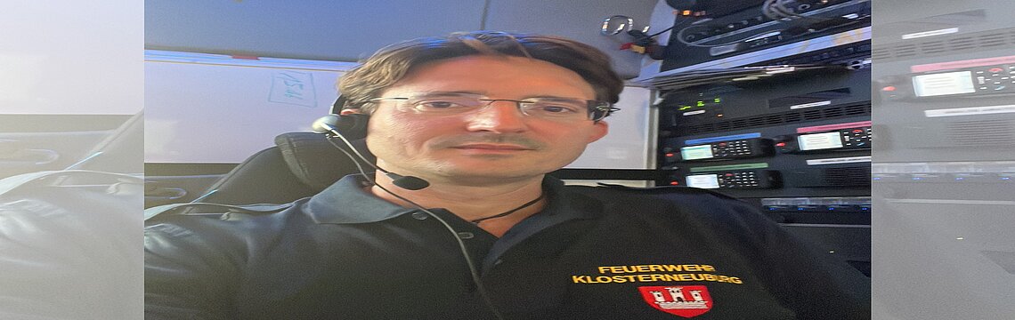 Ein Mann in Feuerwehr-Uniform trägt ein Headset und ist in seine Aufgaben vertieft.