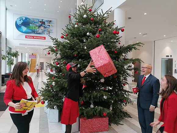 Drei Damen und ein Herr vor einem Weihnachtsbaum.
