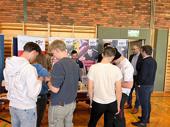 Foto vom TÜV AUSTRIA Infostand. Viele junge Besucher.