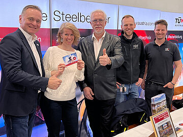 Gruppenfoto: Vier Herren und eine Dame am TÜV AUSTRIA Infostand.