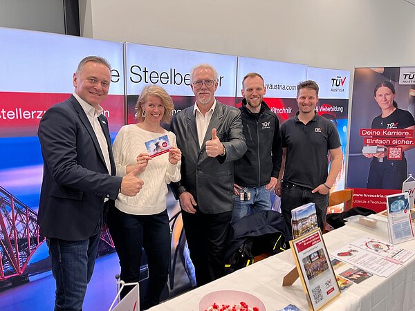 Gruppenfoto beim Messestand: Vier Herren und eine Dame.