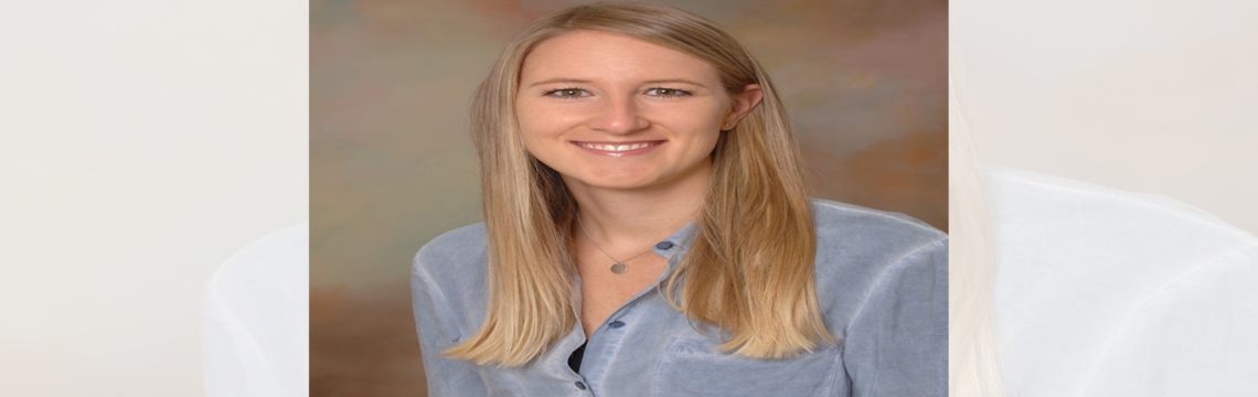 Eine Frau mit langen blonden Haaren trägt ein blaues Hemd.