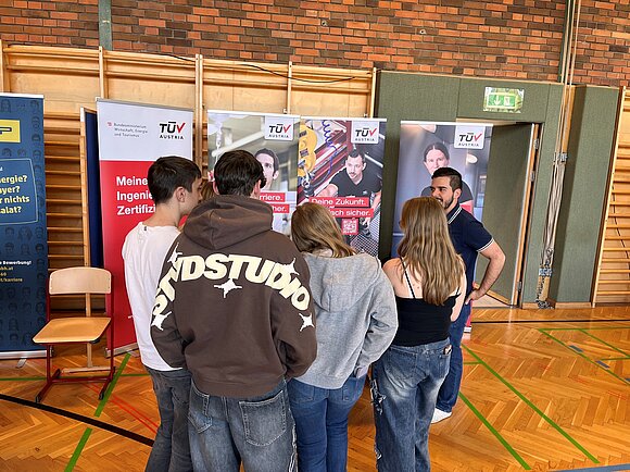 Foto vom TÜV AUSTRIA Infostand. Viele junge Besucher.
