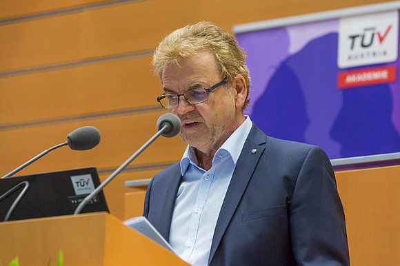 Mann im Anzug spricht hinter Rednerpult