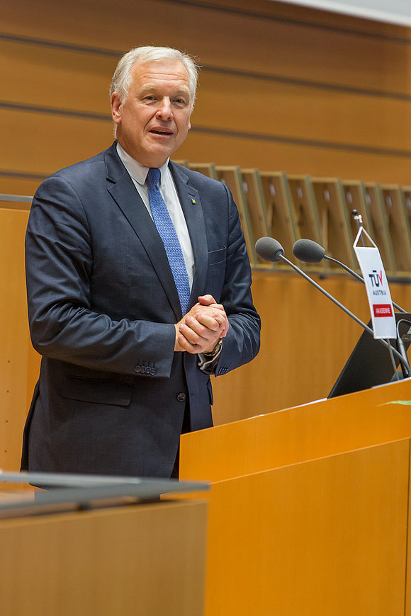 Mann im Anzug spricht hinter Rednerpult