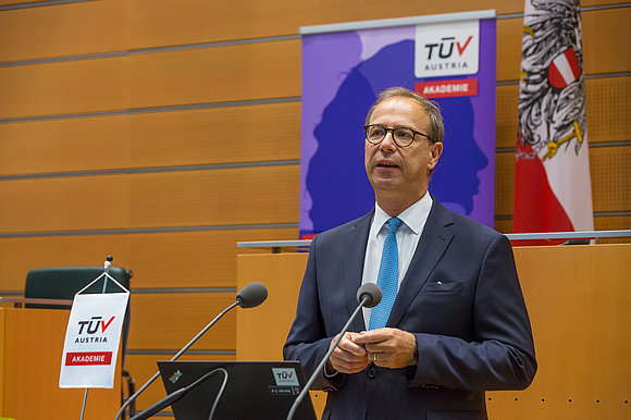 Mann im Anzug spricht hinter Rednerpult