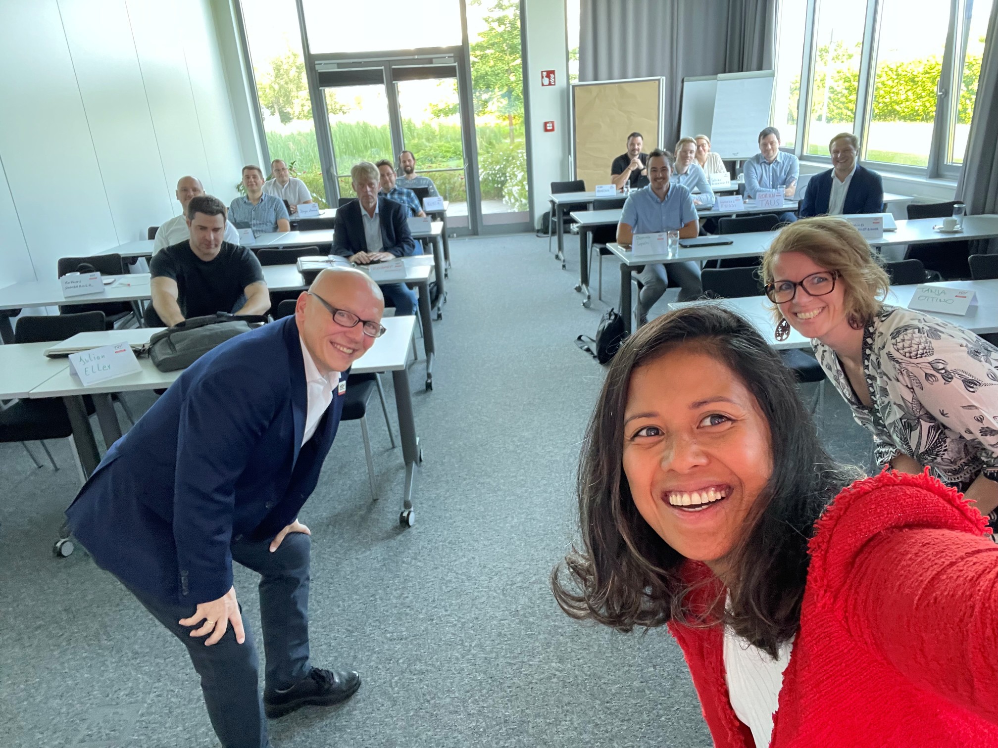 Dame macht Selfie. Hinter ihr sitzen Seminarteilnehmer:innen.