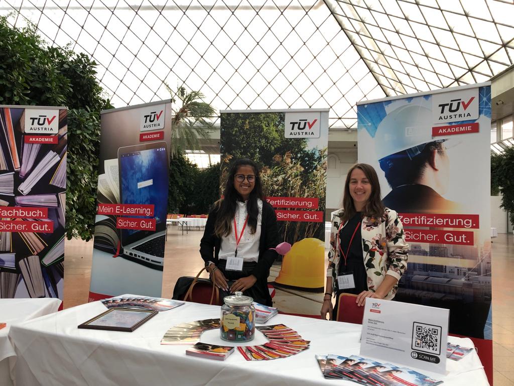Freundliche lächelnde Damen am TÜV AUSTRIA Akademie Messestand.